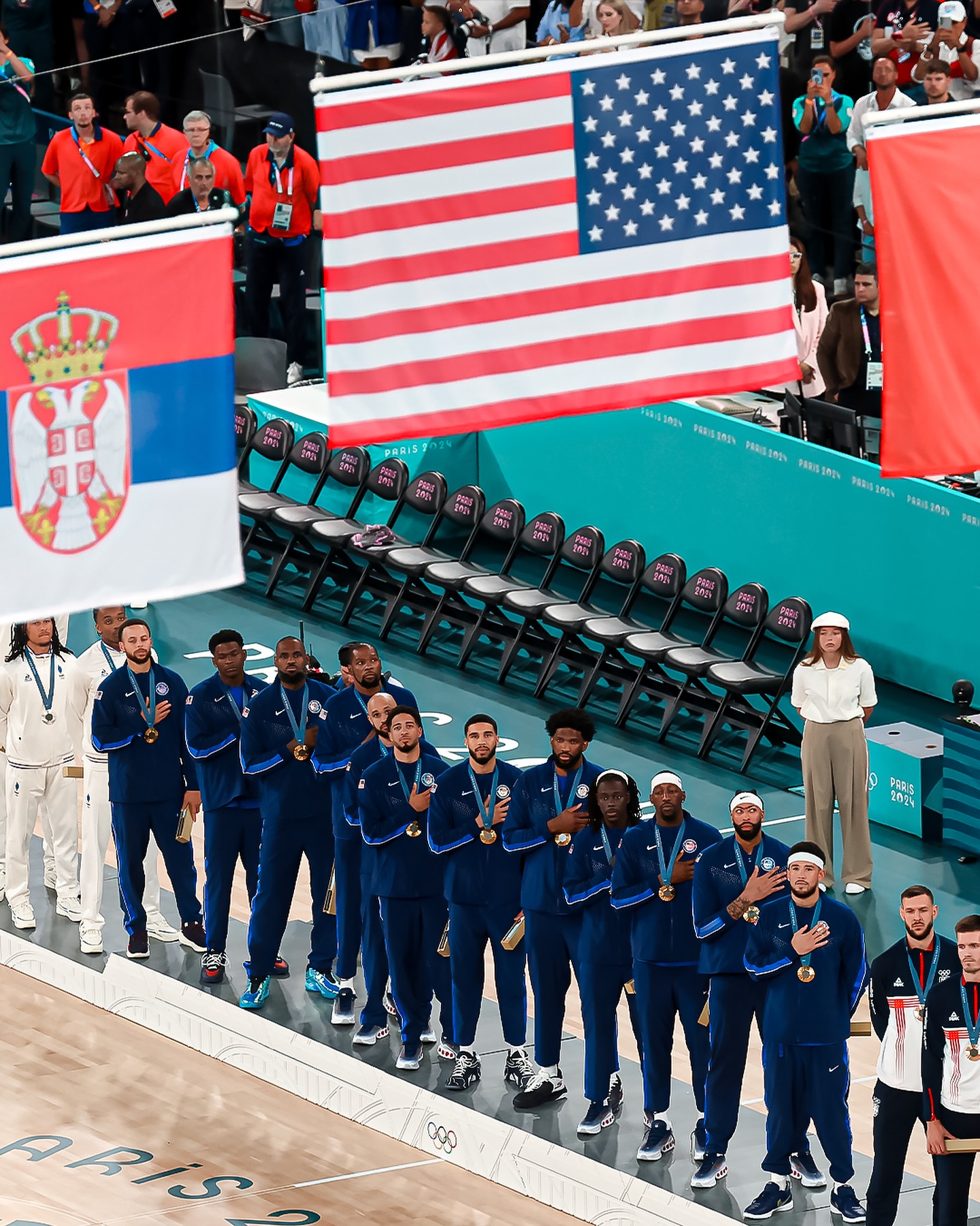 USA Basketball players giving respect to their national anthem after the medal distribution.