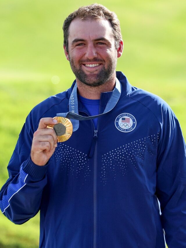 Scottie Scheffler holding gold medal.