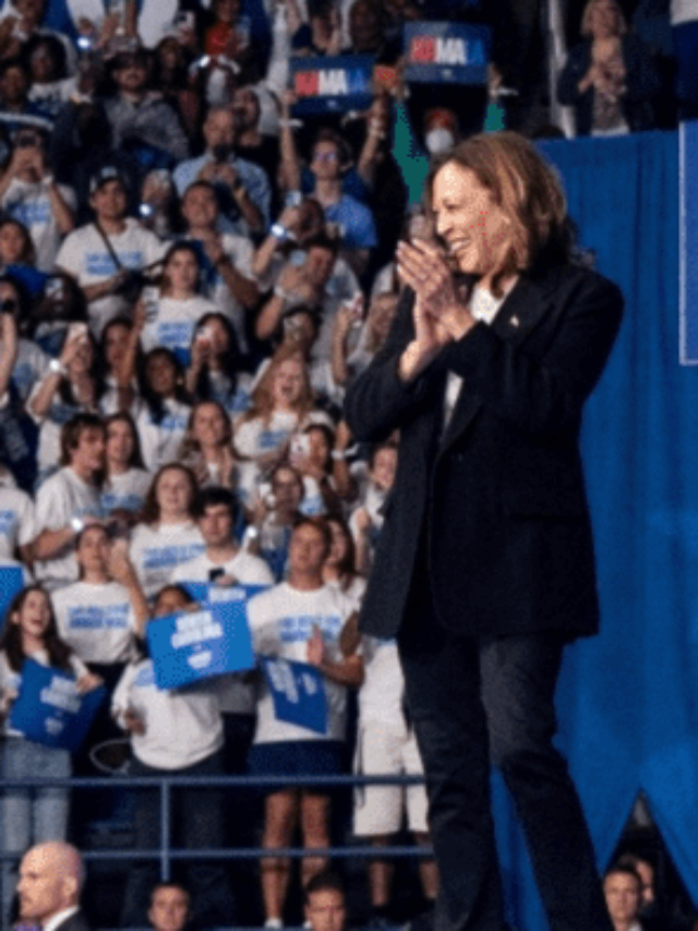 Donald Trump and Kamala Harris are Standing in the room full of people.