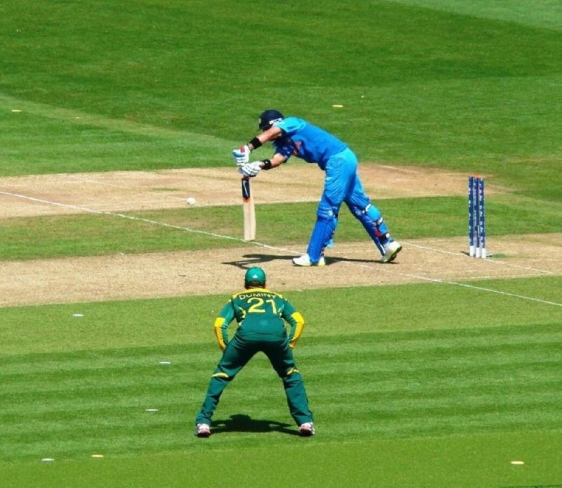 Virat Kohli in blue India Test kit leaning forward to play a front-foot defensive stroke against South Africa at the 2013 ICC Champions Trophy.