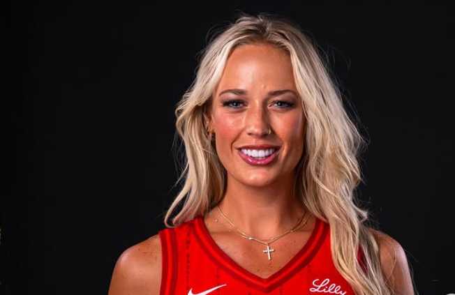 Person wearing a red Indiana Fever jersey (number 8) holding an orange‑white basketball against a black background; Lilly and Salesforce logos visible; Instagram post by sophie_cham