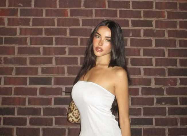 Madison Beer posing in a white strapless dress against a brick wall, from her Instagram account posted in September 2024.