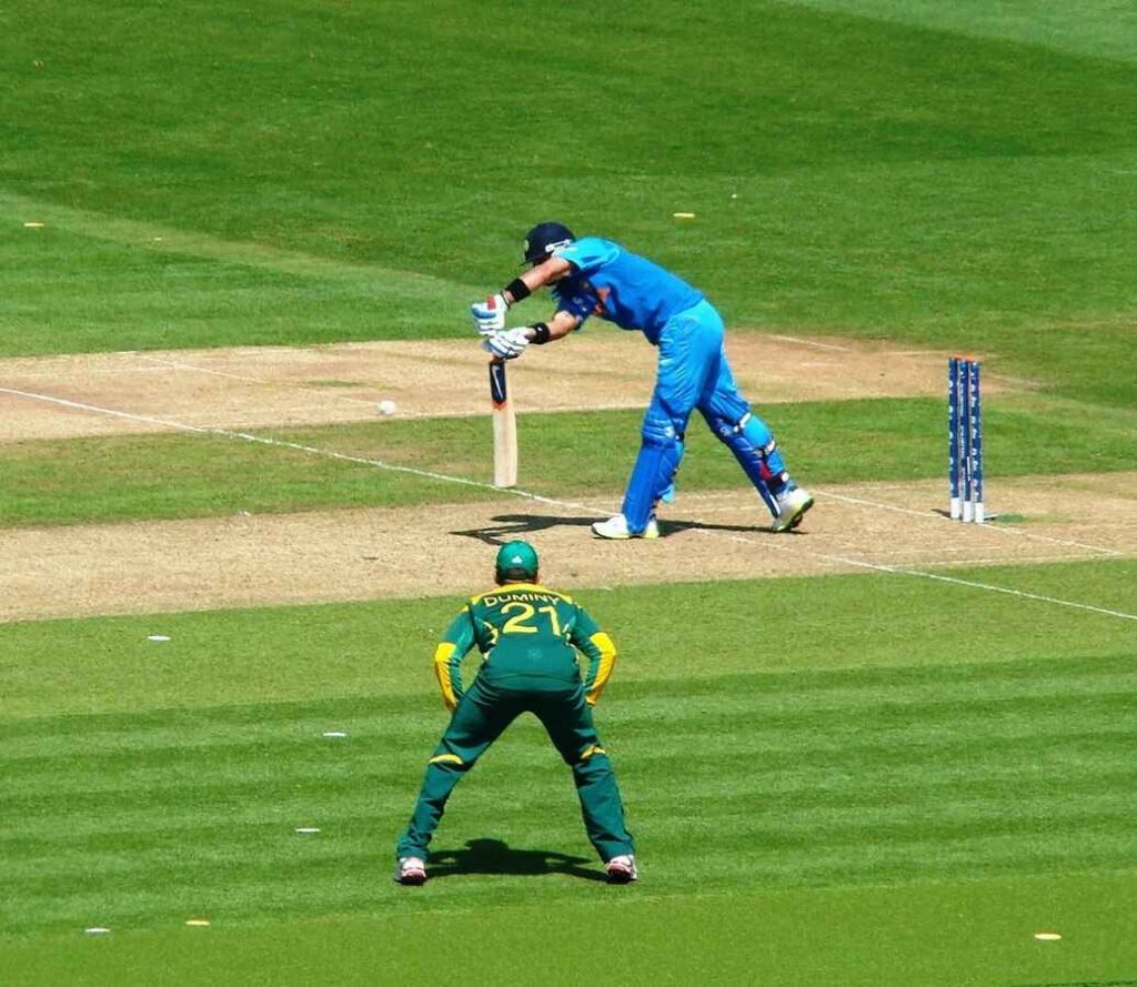 Virat Kohli in blue India Test kit leaning forward to play a front-foot defensive stroke against South Africa at the 2013 ICC Champions Trophy.