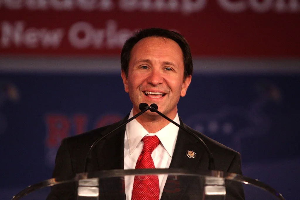 Louisiana Governor Jeff Landry speaking at a podium during a public event, facing audience and media.