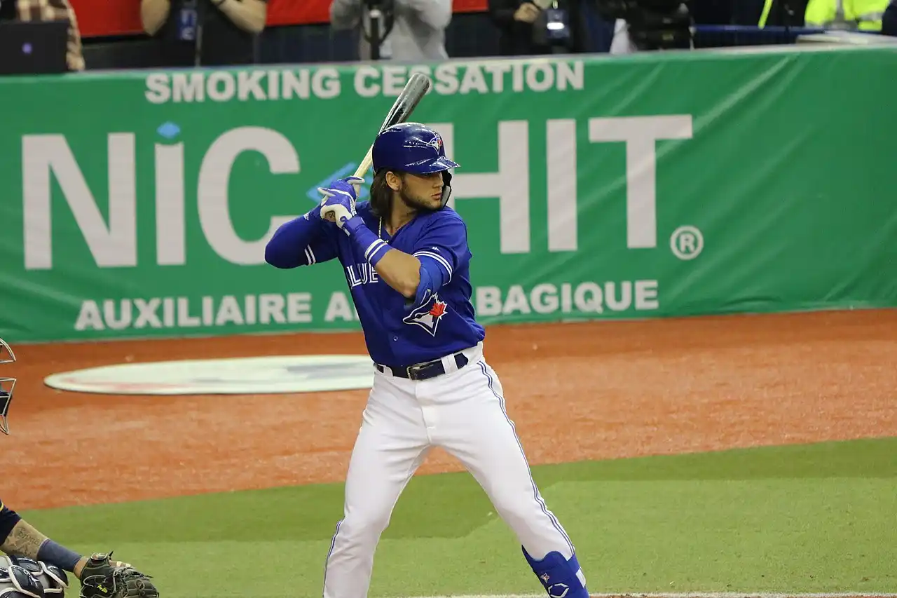 Bo Bichette batting swing in a blue uniform, representing his $126 million signing with the New York Mets and transition to third base for the 2026 MLB season.