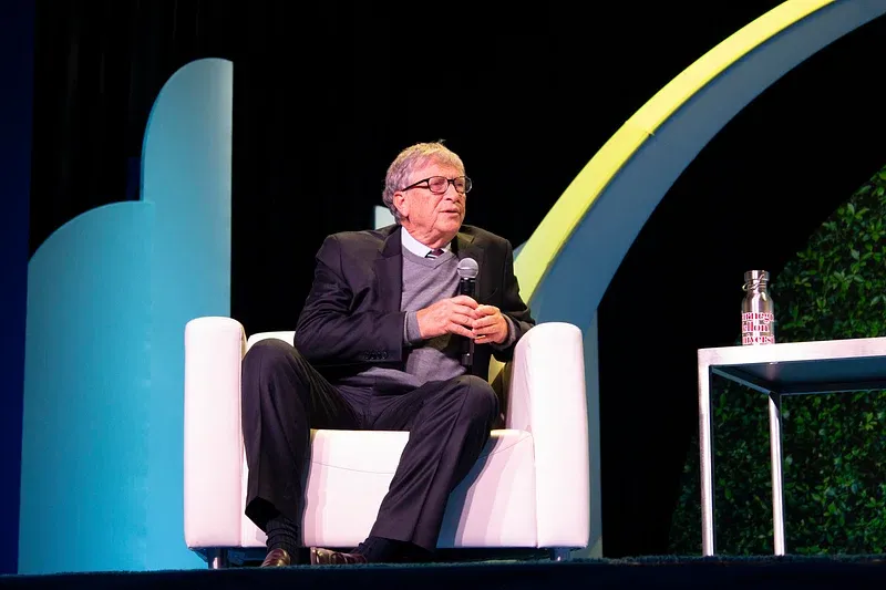 Bill Gates seated on stage speaking at the Global Clean Energy Action Forum 2022 during a panel discussion.