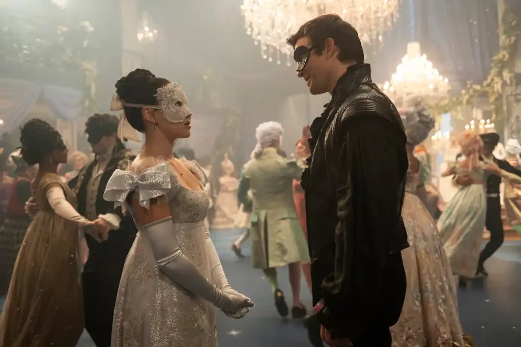 Yerin Ha as Sophie Baek and Luke Thompson as Benedict Bridgerton wearing masks and formal Regency attire at a grand ballroom dance in Bridgerton Season 4.