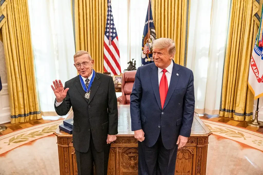 U.S. President Donald Trump presents the Presidential Medal of Freedom to former Notre Dame football coach Lou Holtz in the Oval Office on December 3, 2020.