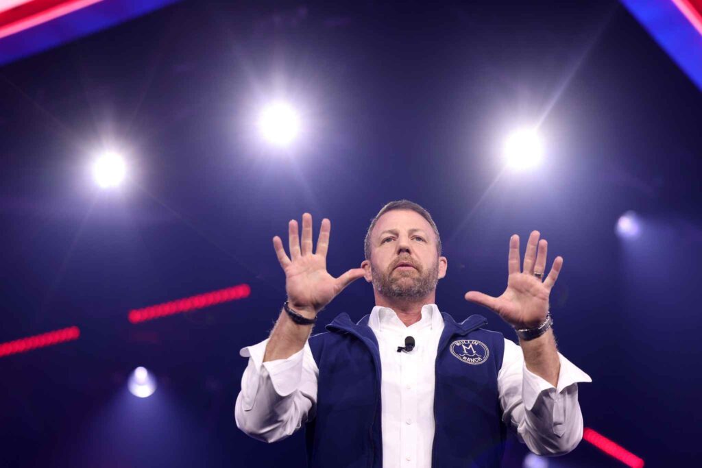 U.S. Senator Markwayne Mullin speaking on stage at AmericaFest 2024 in Phoenix, Arizona, during a public political event.