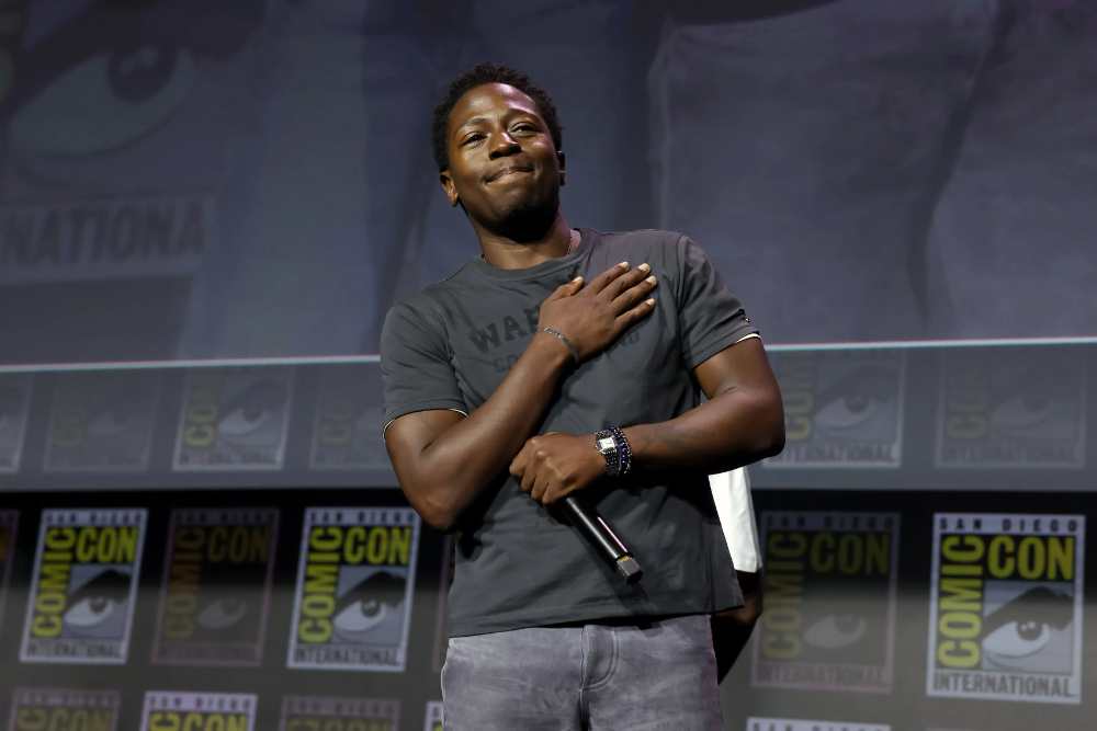David Jonsson stands on stage at San Diego Comic-Con alongside Ryan Coogler, Letitia Wright and Winston Duke during the Marvel Studios panel.