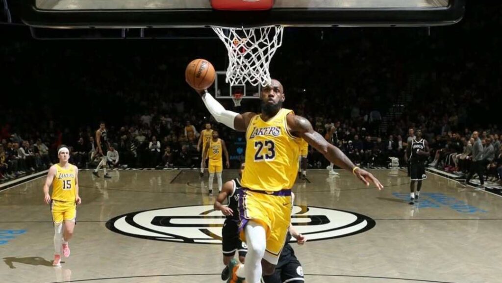 LeBron James in a Lakers uniform, looking focused during a game, representing his recent past as he decides his NBA future.