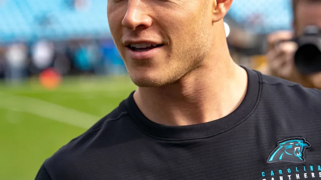 Christian McCaffrey on the sideline in uniform.