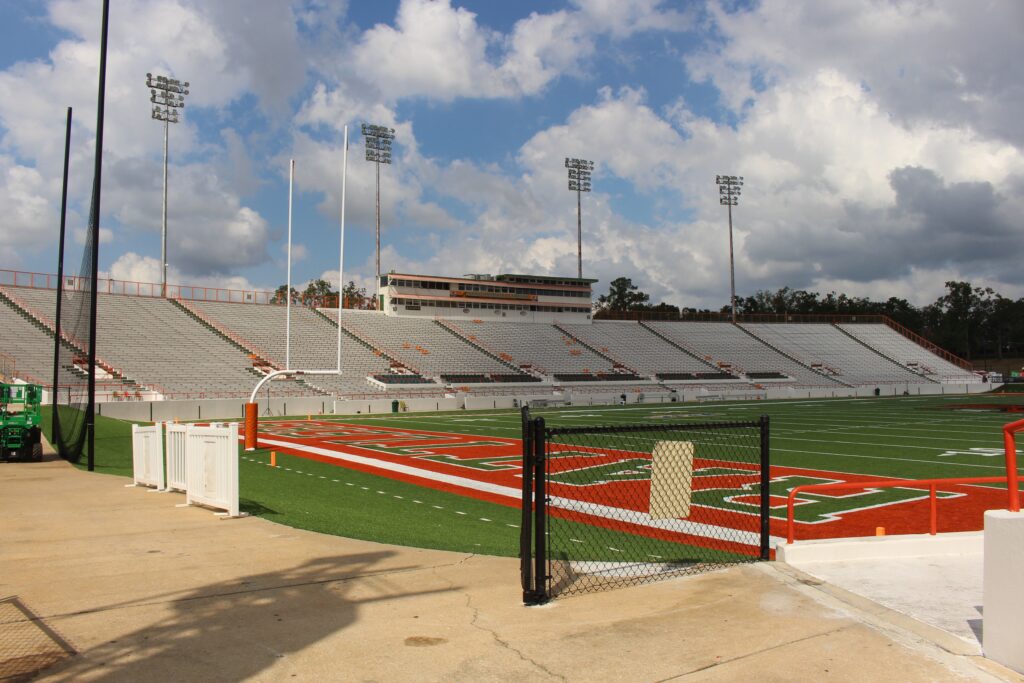 Ground-level view of empty grandstands and turf athletic field at Bragg Memorial Stadium in Tallahassee Florida under daylight