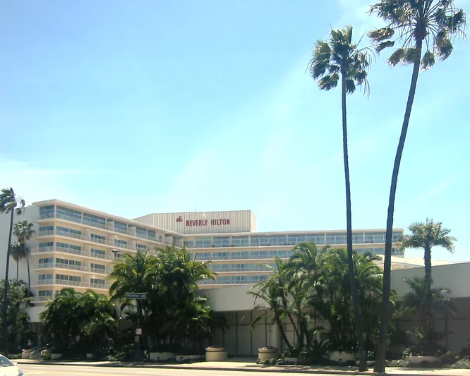 Street-level outdoor perspective of the front driveway and awning of the historic Beverly Hilton Hotel