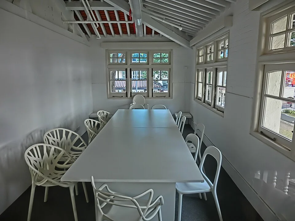Interior perspective of an empty corporate meeting boardroom with sleek rolling chairs and glass perimeter walls