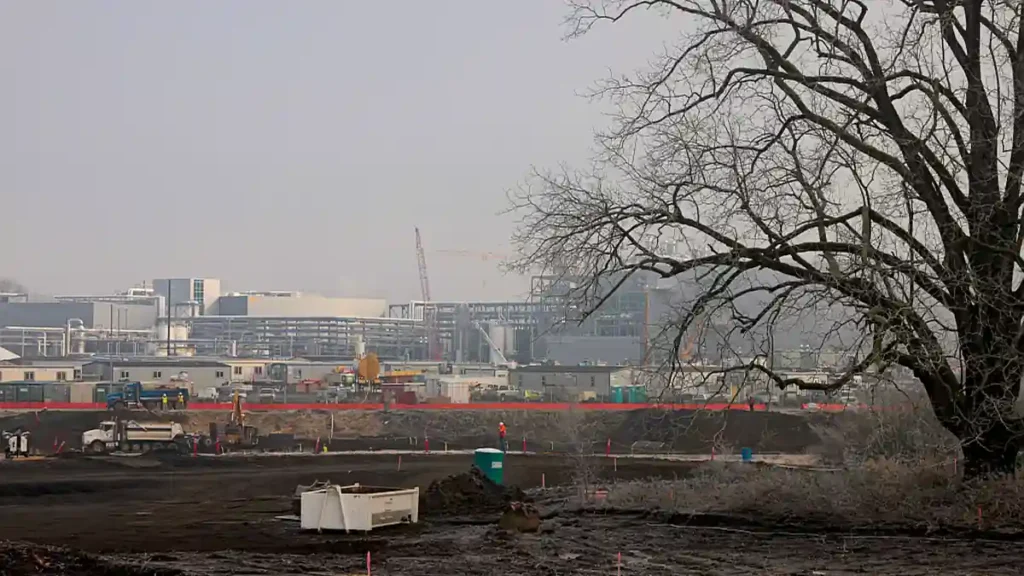 Construction site of an Intel semiconductor fabrication plant with cranes and factory buildings