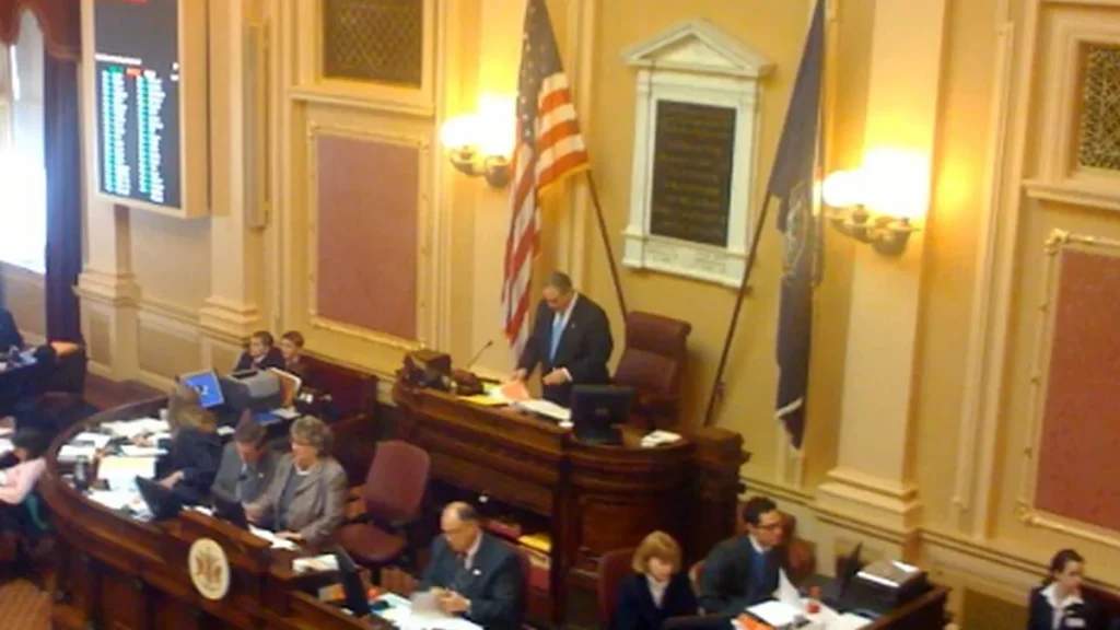 Wide view of the Virginia state Senate chamber in session with lawmakers at their desks in Richmond