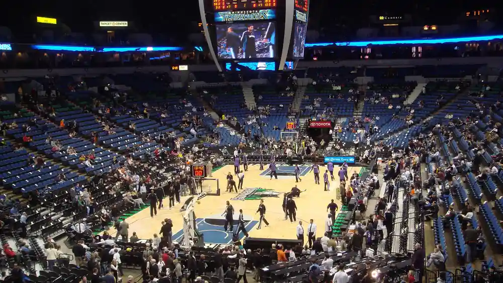 Target Center basketball court with Minnesota Timberwolves logo on the hardwood during pre-game warm-ups.