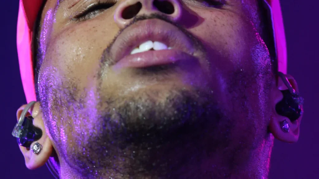 American musician Chris Brown wearing a denim jacket on stage during an appearance.