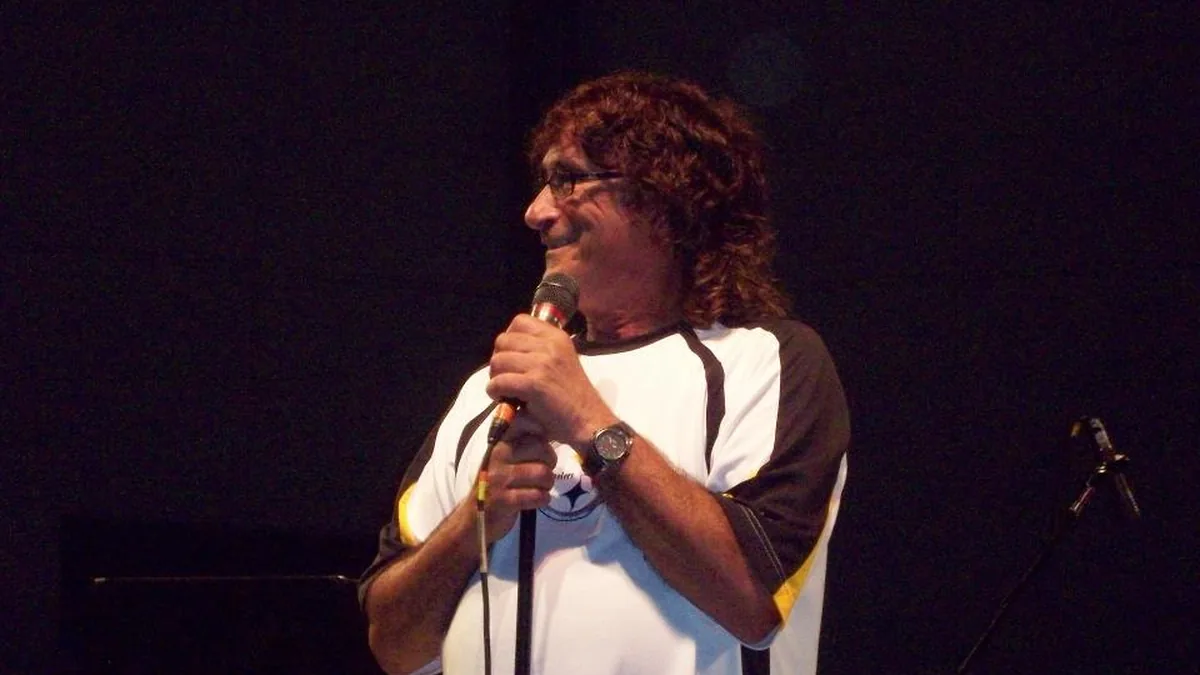 Donnie Iris singing into a microphone on stage with sunglasses during an outdoor concert in Pennsylvania.